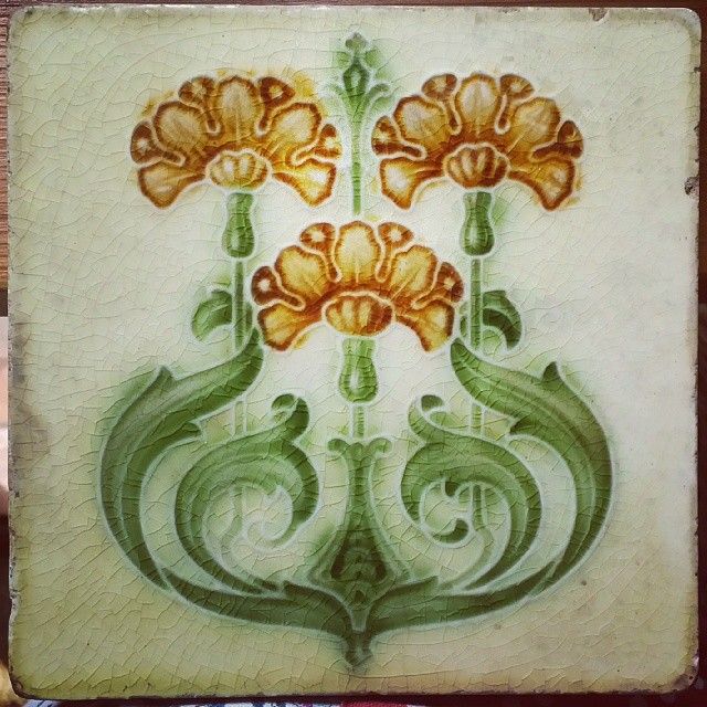 an artistic tile with flowers painted on it