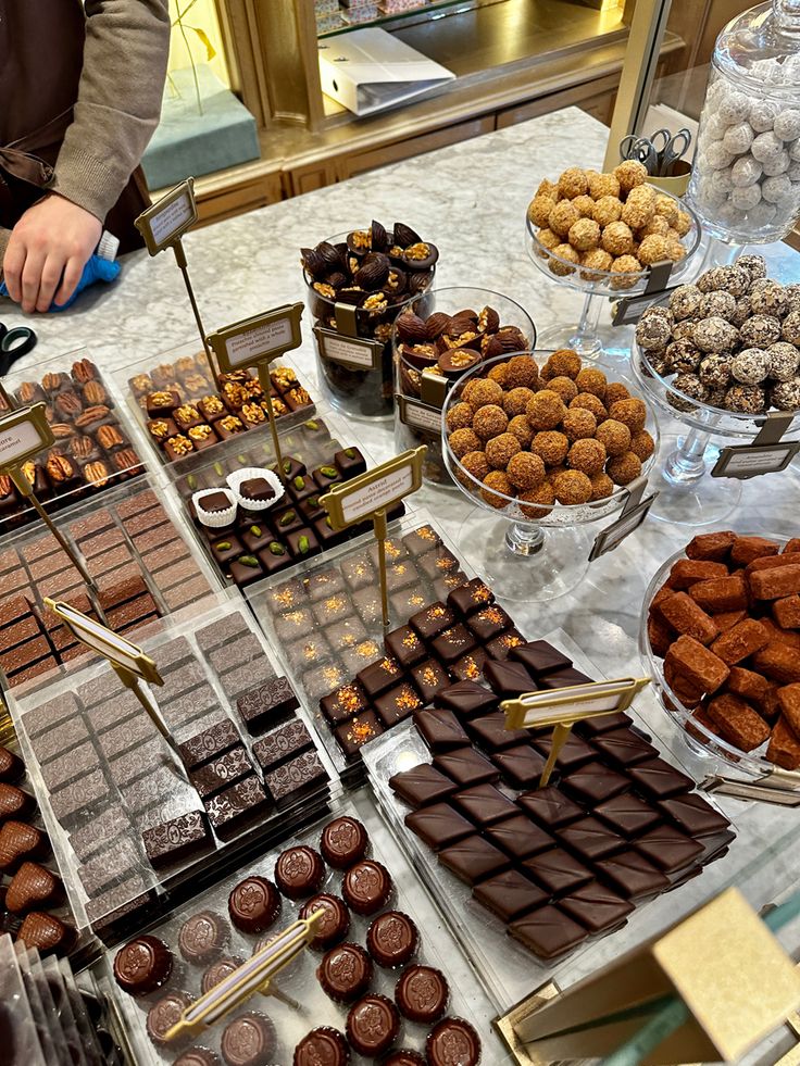 a table topped with lots of different types of chocolates and candies on display