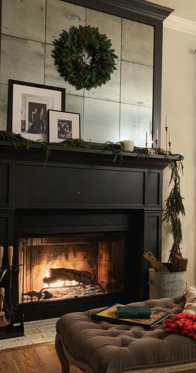 a living room filled with furniture and a fire place in front of a mirror on the wall