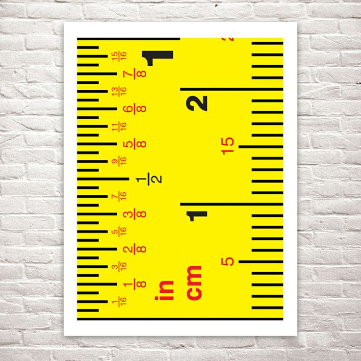 a yellow and red ruler on a brick wall