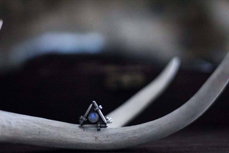 Silver Sword Ring​		
			"And though she be but little, she is fierce."​		
		However the power of three speaks to you, you're sure to find delight in this rainbow moonstone sword ring. Each tiny sword is handcrafted one at a time and carefully assembled into a triangle with a tiny rainbow moonstone center. Topping off this gorgeous compilation is a celtic infinity knot band.Crafted entirely by hand from raw, solid fine and sterling silverRING TOP: 18mm X 18mmCABOCHON 6mm Hand Forged Moonstone Ring In Sterling Silver, Mystical Moon Phase Jewelry For Promise, Spiritual Sterling Silver Moonstone Promise Ring, Spiritual Moon Phase Promise Rings, Spiritual Hand Forged Moonstone Rings, Witchy Ring, Celtic Infinity Knot, The Power Of Three, Power Of Three