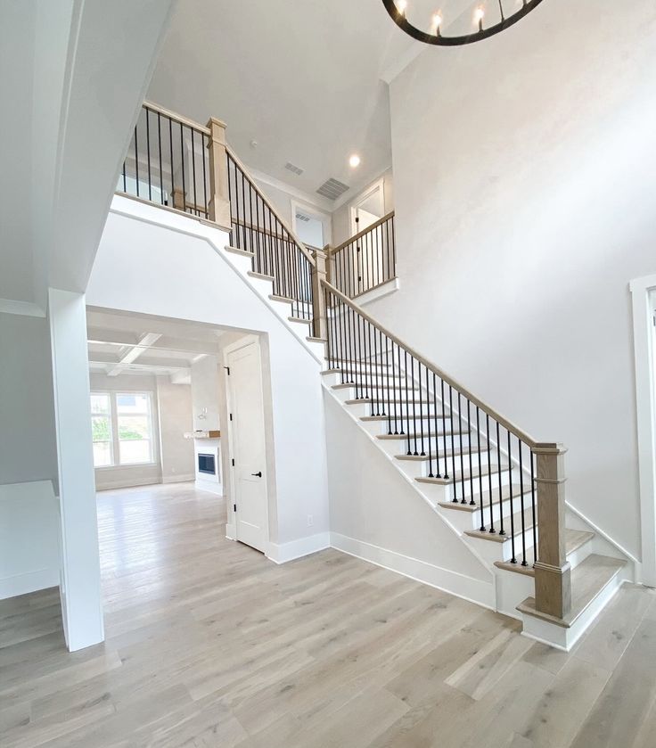 an empty living room with stairs leading to the second floor and another door on the other side