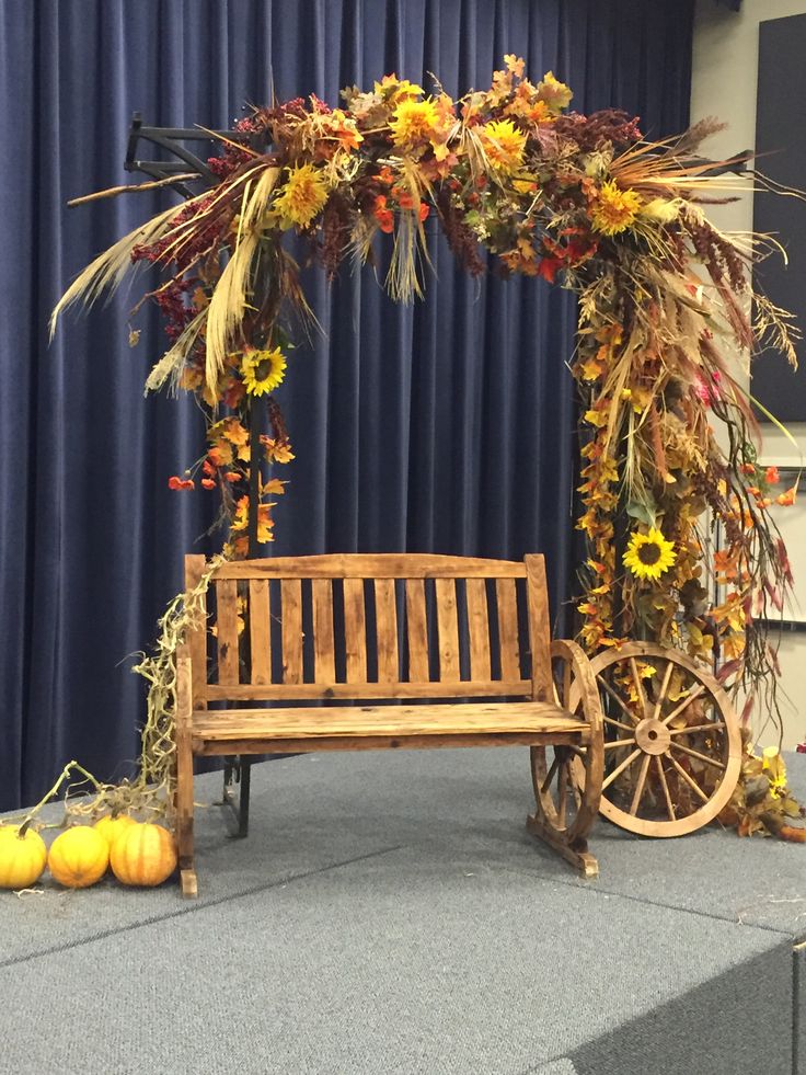 a wooden bench sitting in front of a blue curtain with flowers and leaves on it