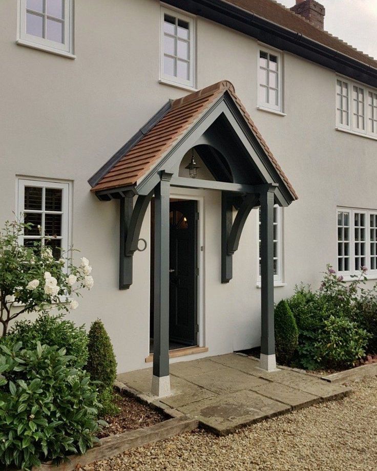 a white house with a black door and brown roof