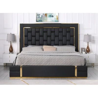 a black and gold bed with two nightstands next to it in a white room