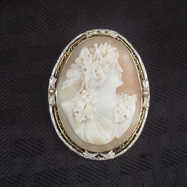 Cameo Edwardian Vintage Filigree 14K White Gold Carved Brooch Pearl Pendant. Stunning yellow and white gold filigree cameo brooch pin pendant. Measures 1 7/8" x 1 3/8" wide and weighs 14.4 grams. Made of yellow and white gold and the only issue I see is missing the bottom pearl from the frame. As always please see photos for details of the exact item you're buying. My items are sold as is and no returns. I take pride in providing quality photos with a quality description to ensure no returns or Heirloom Cameo Brooch For Wedding, Heirloom Cameo Wedding Brooch, Heirloom Cameo Brooches For Weddings, Victorian Style Cameo Brooch For Weddings, Victorian Cameo Brooch For Wedding, Antique Cameo Brooches For Wedding, Ornate Oval Carved Brooches, Ornate Carved Oval Brooches, Carved Oval Brooch For Formal Occasions