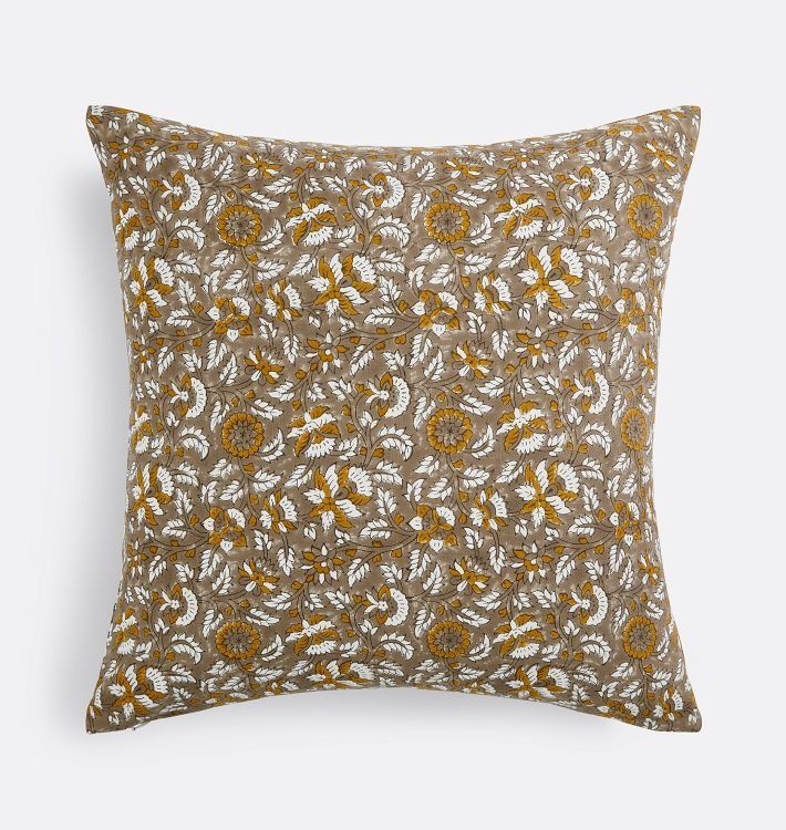 a brown and white pillow with yellow flowers on it