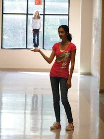 a woman standing in front of a window holding a cell phone