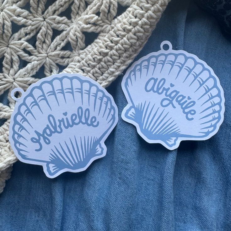 two blue stickers with the word annie and an ocean shell on them