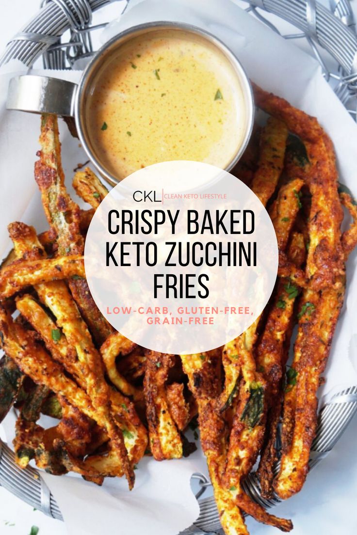 crispy baked keto zucchini fries on a white plate with a bowl of dipping sauce