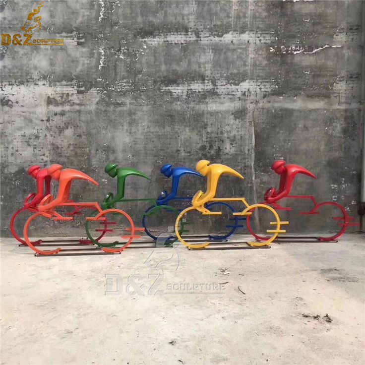 four different colored plastic birds on sleds in front of a concrete wall and cement floor