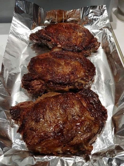 three pieces of meat sitting on top of aluminum foil