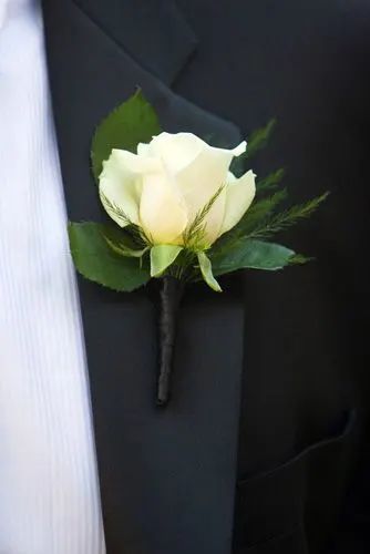 a boutonniere with a white rose on it