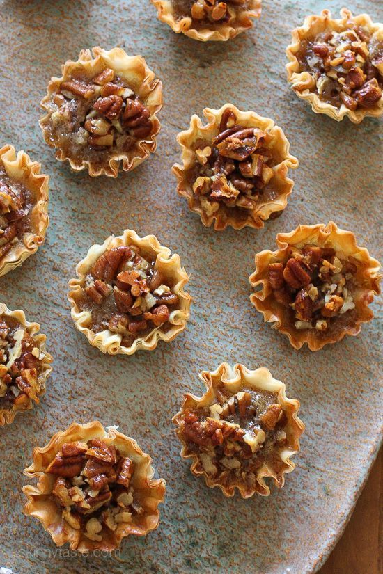 nine pecan pies on a baking sheet ready to be baked