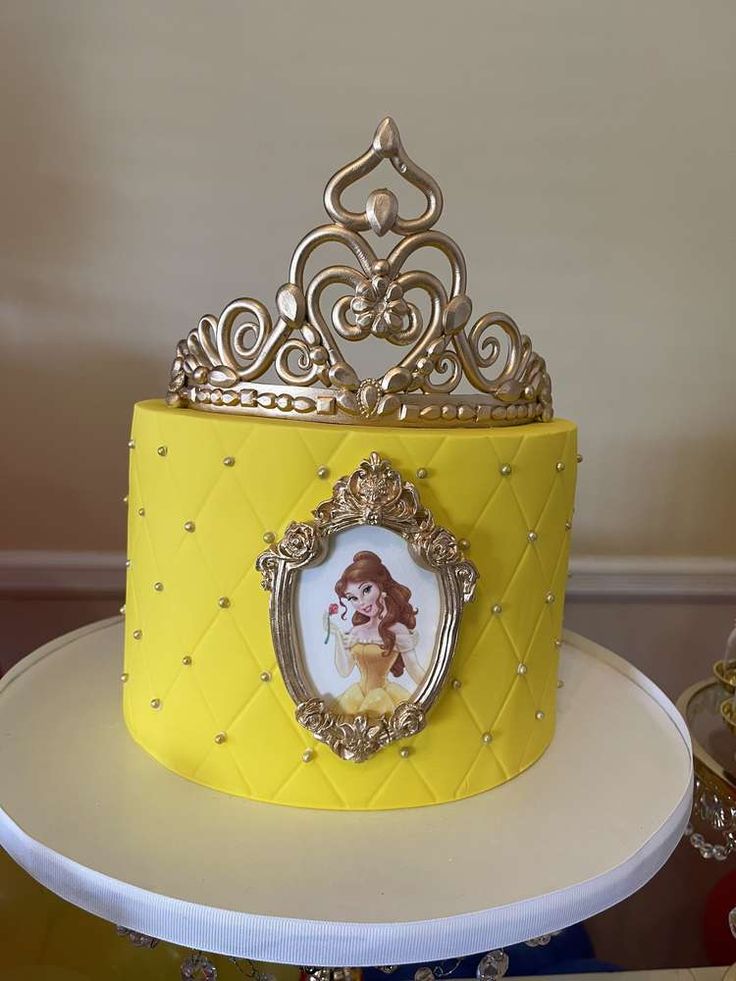 there is a yellow cake with a gold crown on top and a picture frame in the middle