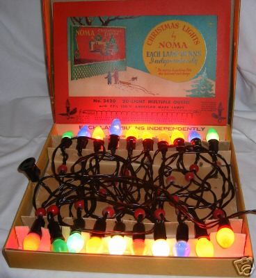 an open box filled with christmas lights on top of a bed