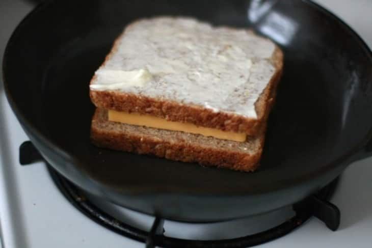 a toasted sandwich is sitting in a frying pan on the stove top, ready to be cooked