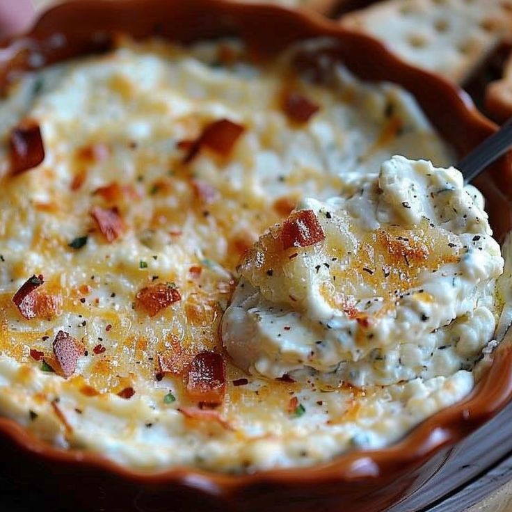 a bowl filled with cheese and bacon dip