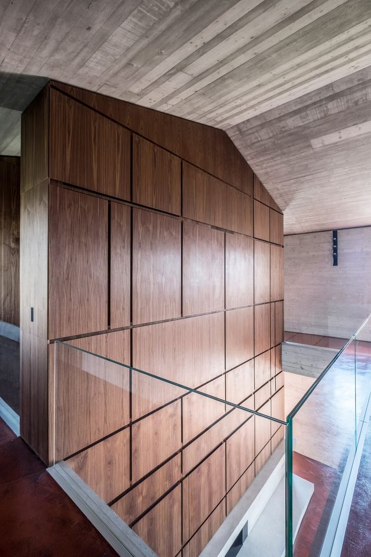 an empty room with wood paneling and glass railings