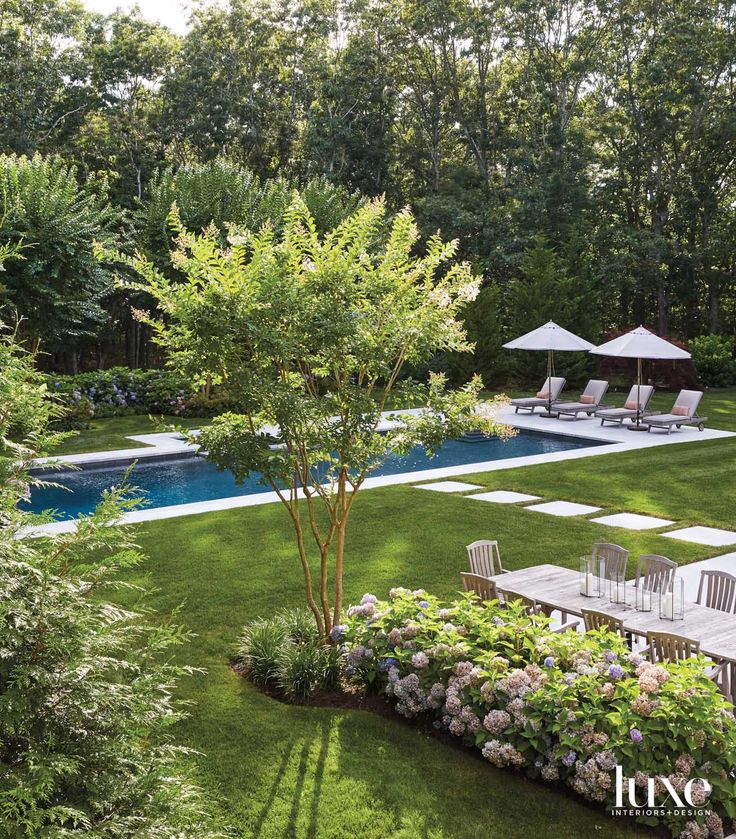 an aerial view of a backyard with lawn, pool and patio furniture in the foreground