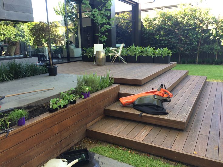 an outdoor patio with wooden steps and plants