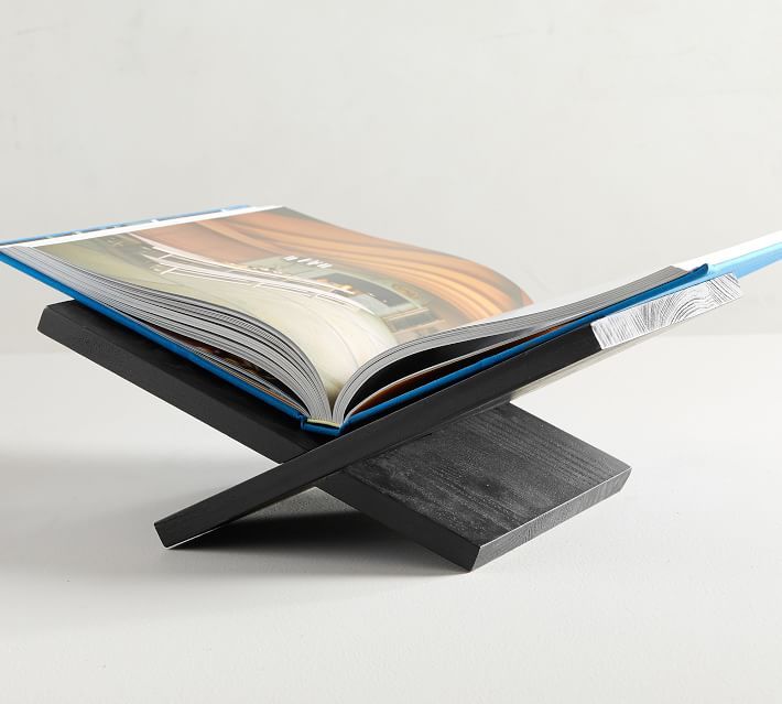 an open book sitting on top of a wooden stand