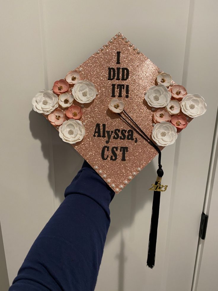 a pink and black graduation cap with flowers on it that says did it alyssa cst?