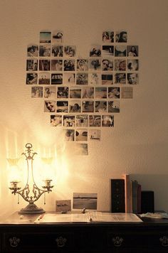 a heart shaped wall hanging on the side of a wall with many pictures attached to it