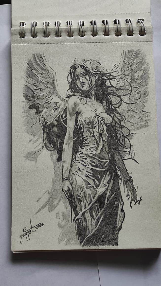 a drawing of a woman with wings on top of a notepad next to a pen