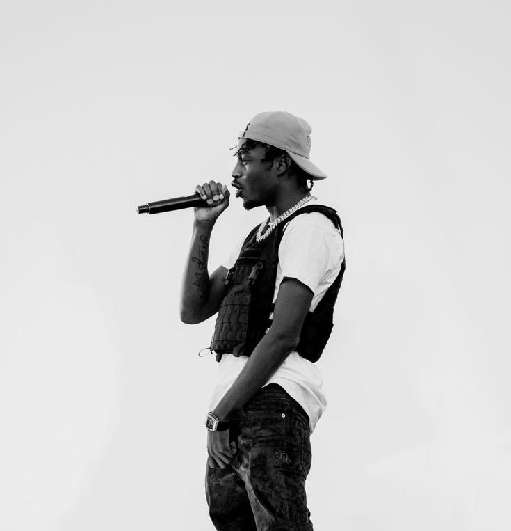 a man standing on top of a skateboard holding a microphone