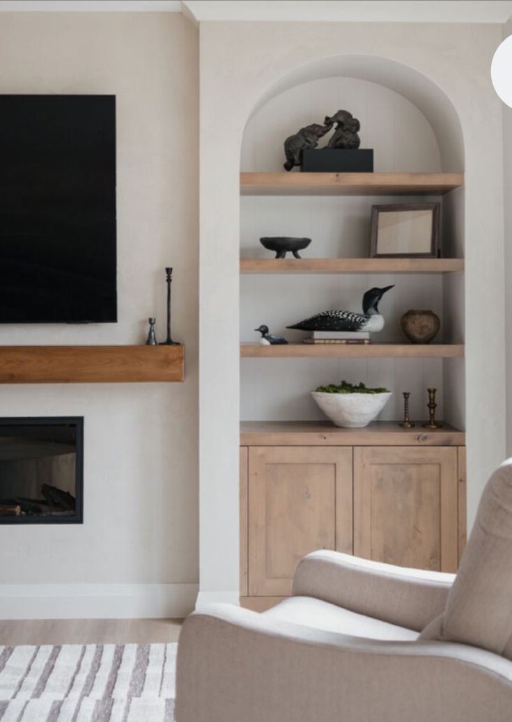 a living room filled with furniture and a flat screen tv mounted on the wall above a fireplace