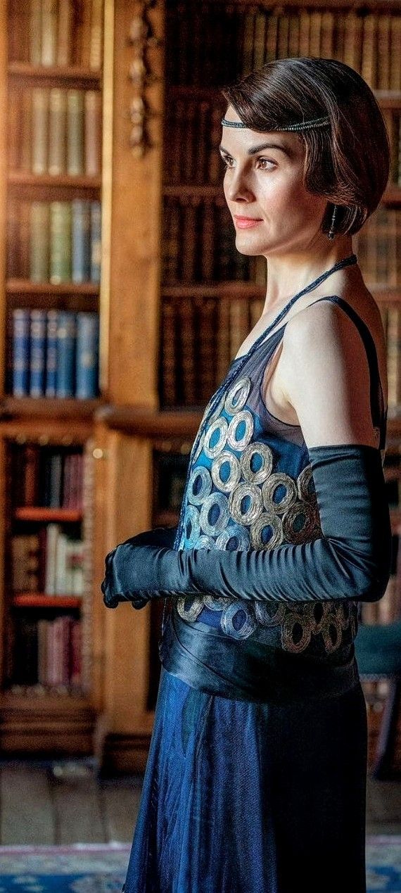 a woman standing in front of a bookshelf with her hands on her hips