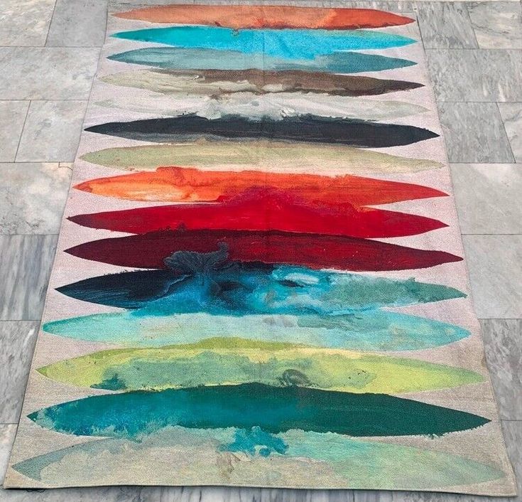 a multicolored area rug on the ground with different shapes and colors in it