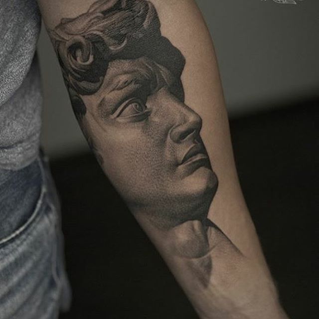 a man's arm with a portrait of a man on it and his head in the background