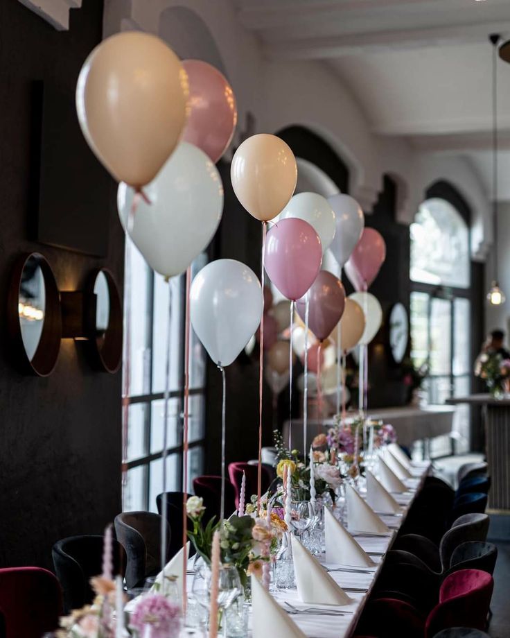 a long table topped with lots of balloons