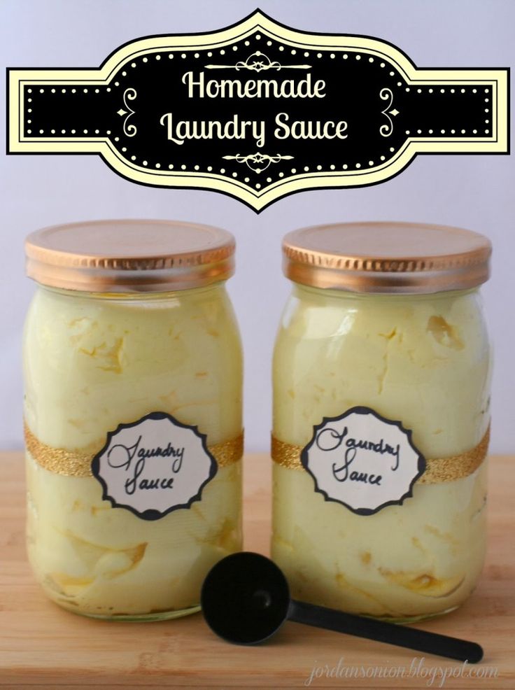 two jars filled with homemade laundry sauce on top of a wooden table