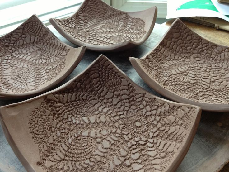 four brown bowls sitting on top of a table