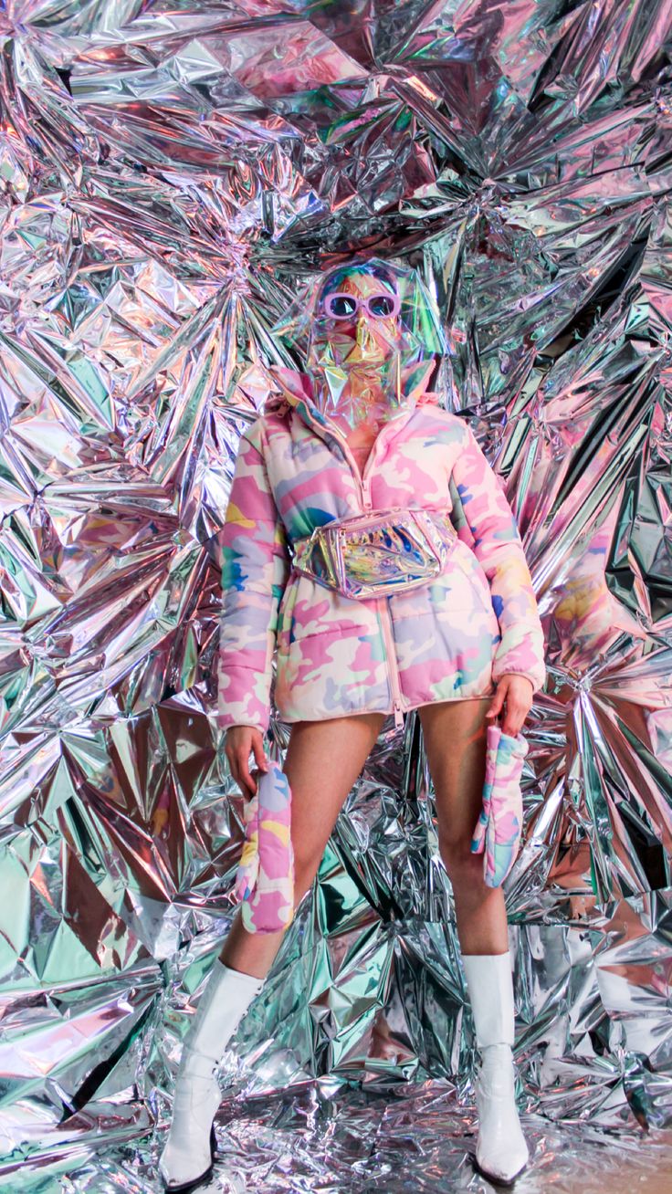 a woman standing in front of a mirror wall with lots of foil covering her face