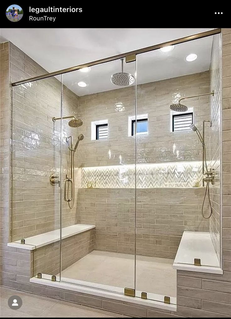 a walk in shower sitting next to a white bath tub under two recessed lights