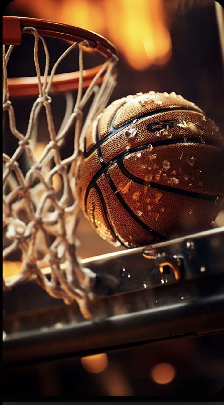 a basketball going through the net with it's reflection on the basket ball below