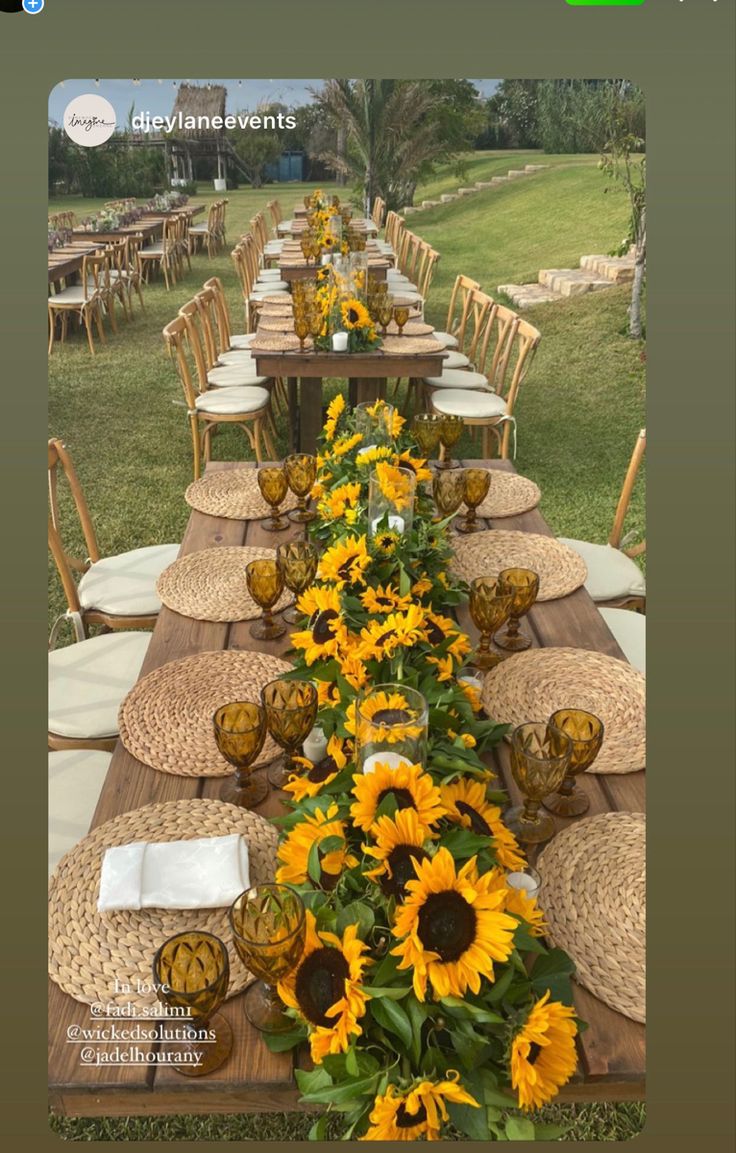 the table is set with sunflowers and place settings for people to sit at