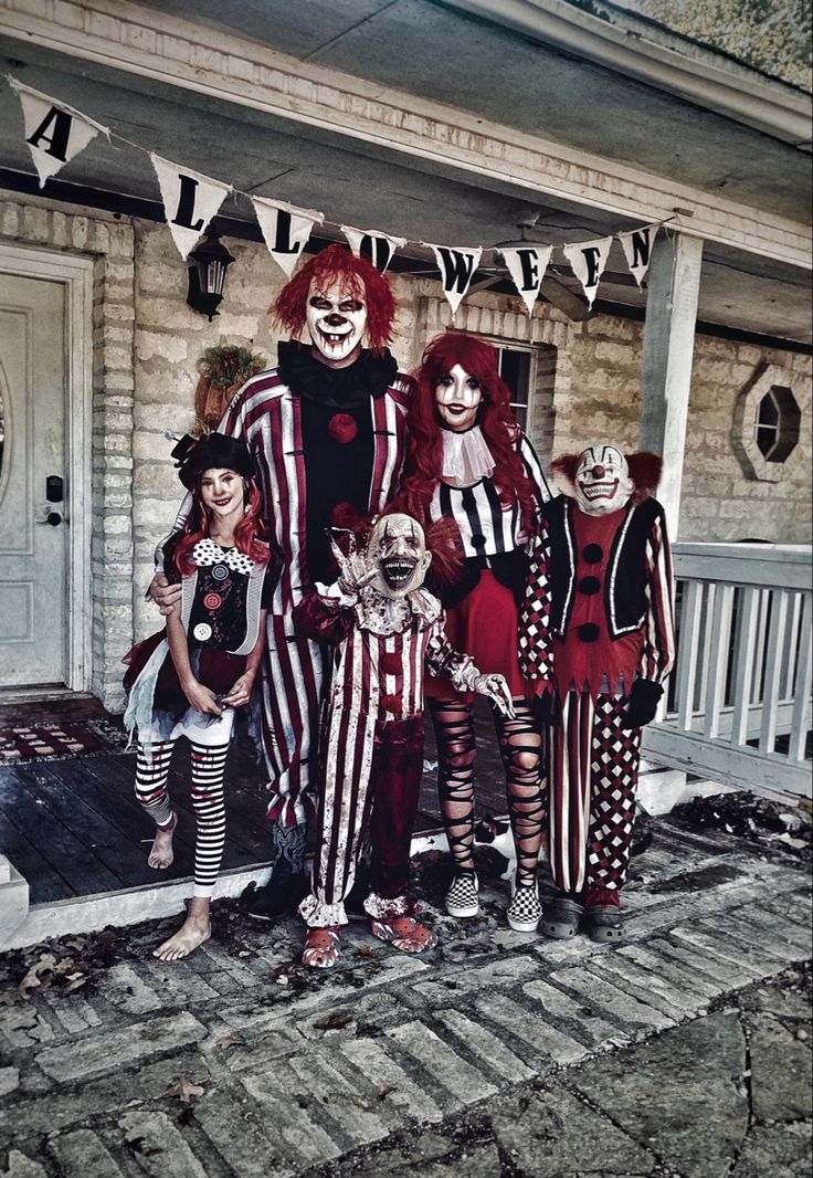 a group of people dressed up as clowns in front of a house for halloween