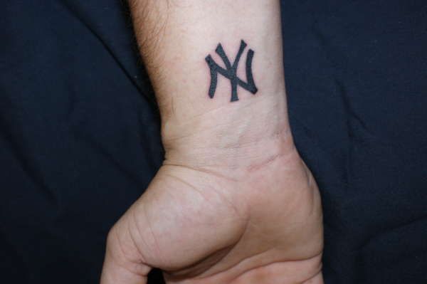 a person's wrist with a tattoo on it that has the new york yankees written on it