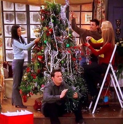 friends decorating a christmas tree on the set of friends and family tv show in their living room