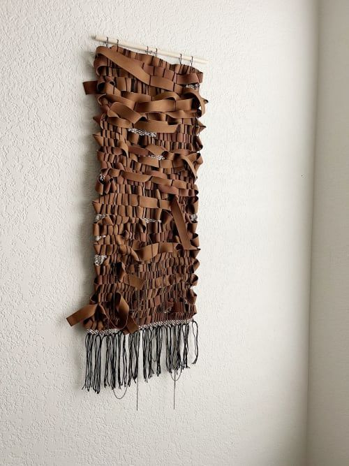 a wall hanging made out of brown leather strips