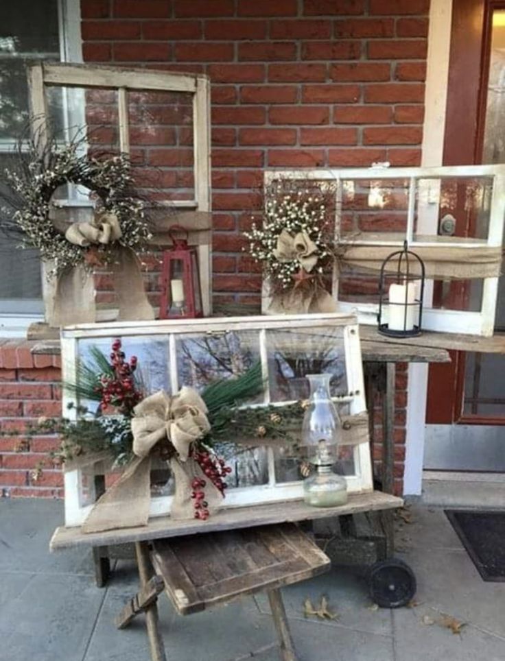 an old window is decorated with wreaths and other decorations for the front door to display