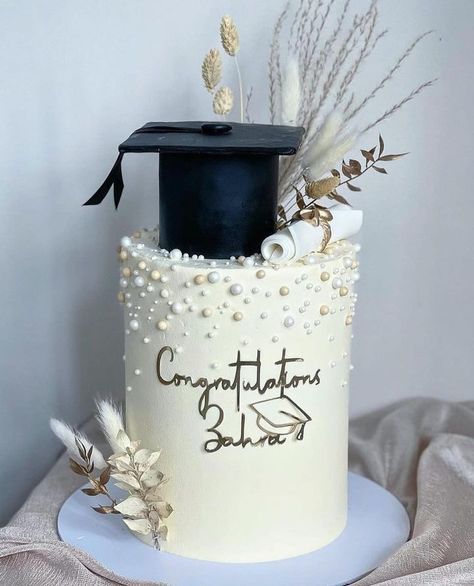 a graduation cake decorated with pearls and feathers