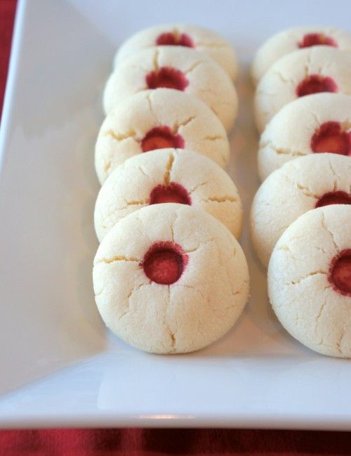 small cookies with red filling on a white plate