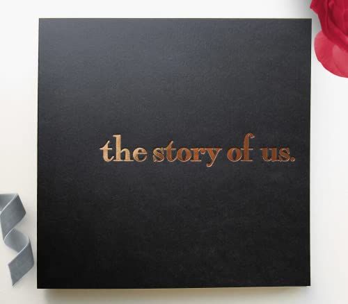 the story of us is written in gold foil on a black book next to a red rose