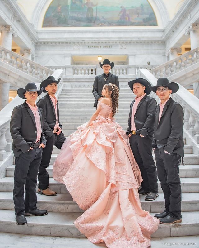 a group of men and women in cowboy hats standing on the steps of a building